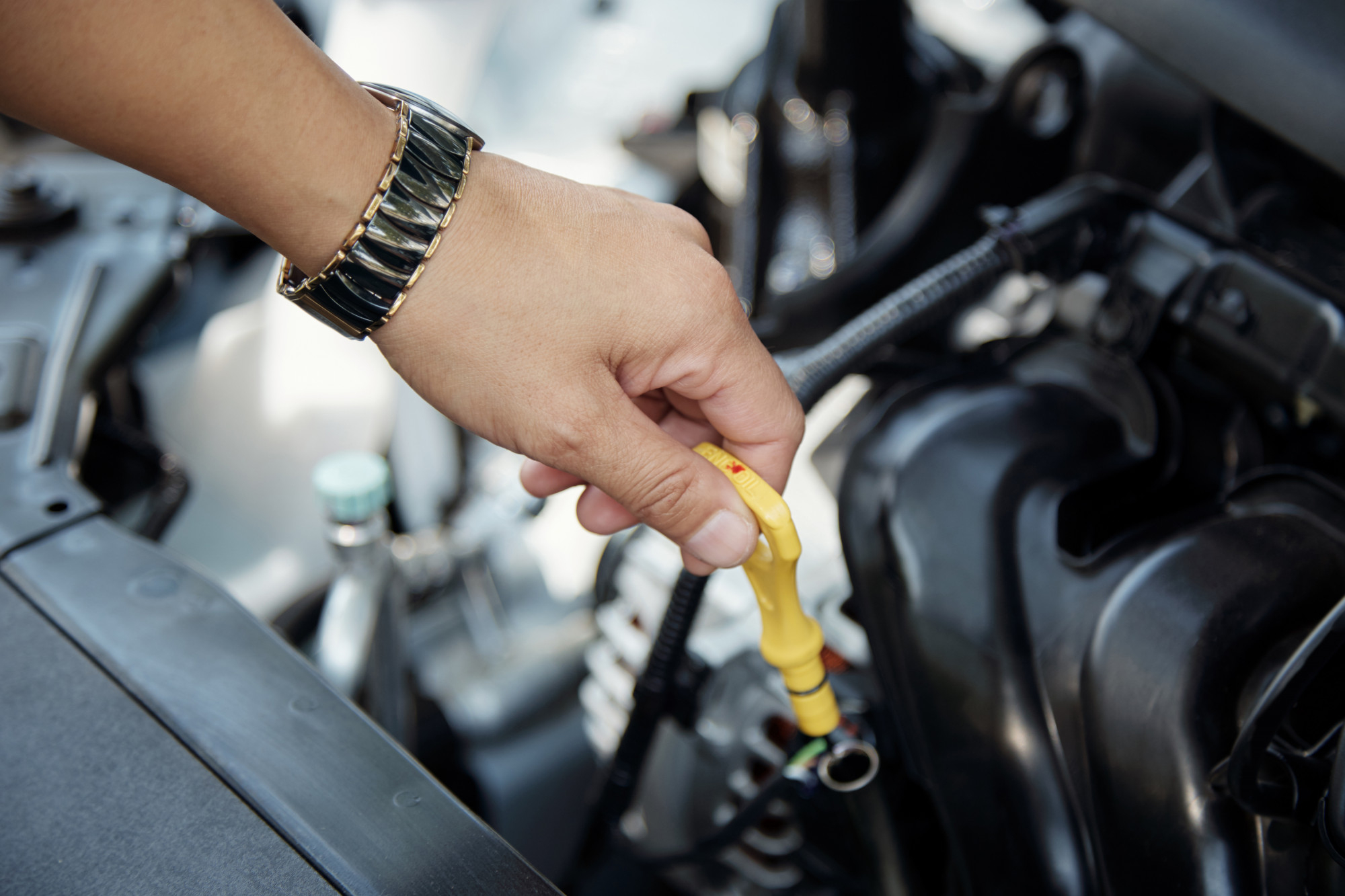 Mechanic checking engine oil level